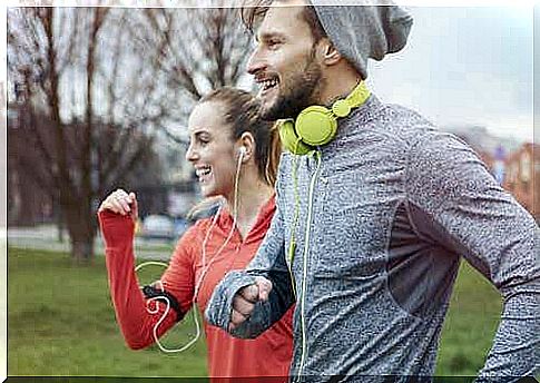 Two people run through a park with smiling faces