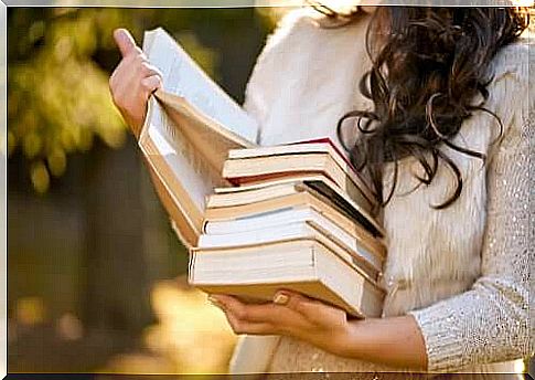 A woman with a stack of books