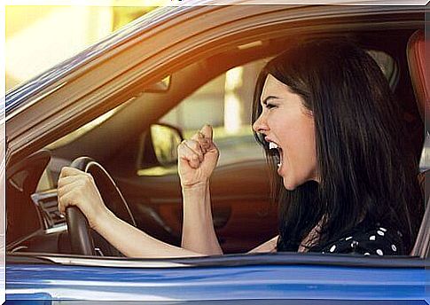 Angry woman in the car traffic aggression