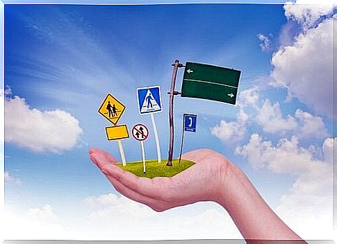 A hand holds road signs