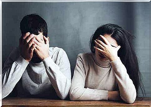 A man and a woman hold their hands to their faces