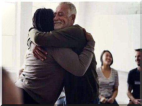 A hug between two people in a support group