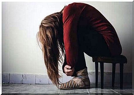 A woman is leaning forward on a stool